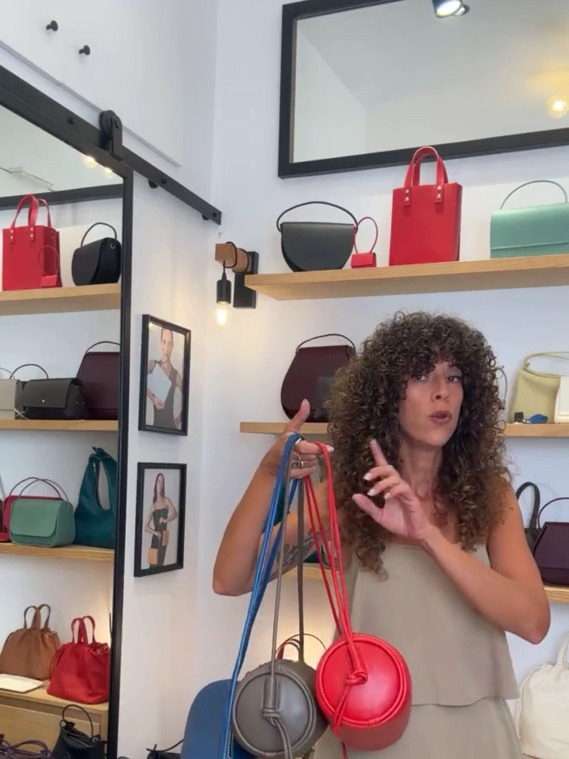 Irene sosteniendo bolsos tubulares de piel colgando durante el directo de San Juan